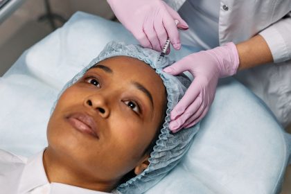Profissional de saúde aplica um produto injetável na testa de uma mulher em uma clínica de estética.