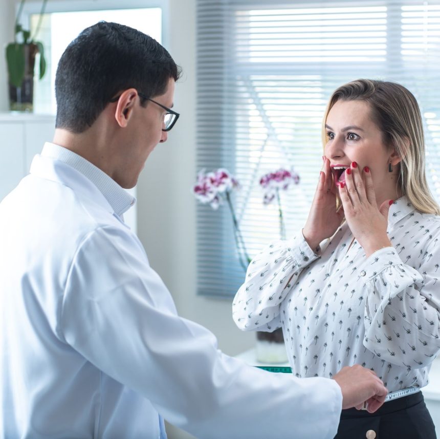 Mulher durante consulta médica, enquanto um profissional mede sua cintura em uma clínica.