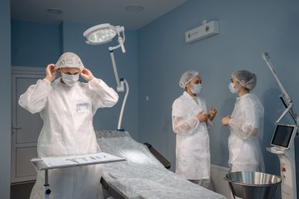 Profissionais de saúde com roupas de proteção conversam em um centro cirúrgico moderno.