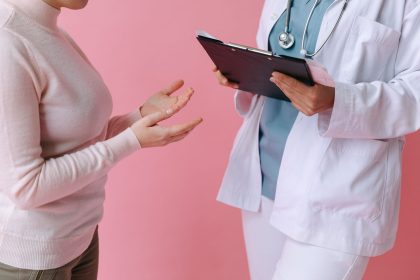 Paciente conversa com uma profissional de saúde durante uma consulta médica.
