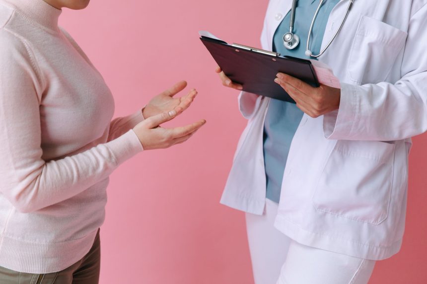 Paciente conversa com uma profissional de saúde durante uma consulta médica.