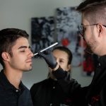 Cirurgião marca o rosto de uma paciente durante uma avaliação para procedimento estético em ambiente clínico.