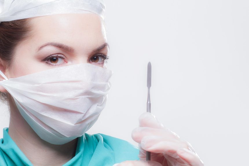 Cirurgião utiliza um sistema robótico durante um procedimento em ambiente hospitalar.
